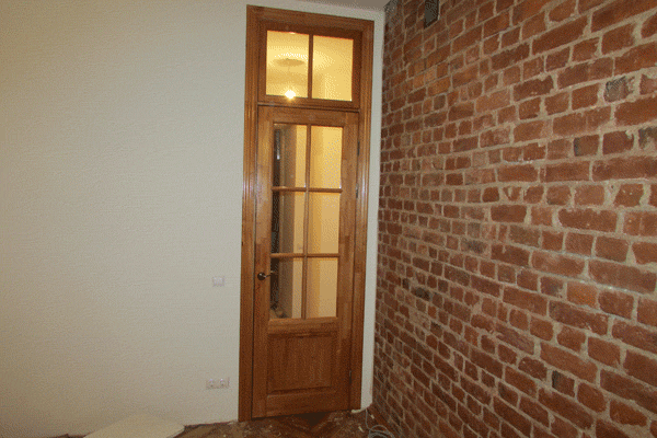 Фото одностворчатой двери КЛАССИКА с фрамугой сверху. Во фрамуге установлен горбылёк визуально продливающий вертикальный горыблёк в полотне. Двери покрашены лаком.