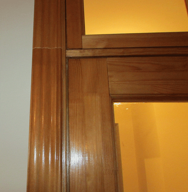 Вблизи фрагмент двери, на котором хорошо видно как стыкуются коробка, полотно, импост и фрамуга. Также виден стык наличников, это встречается если высота большая.