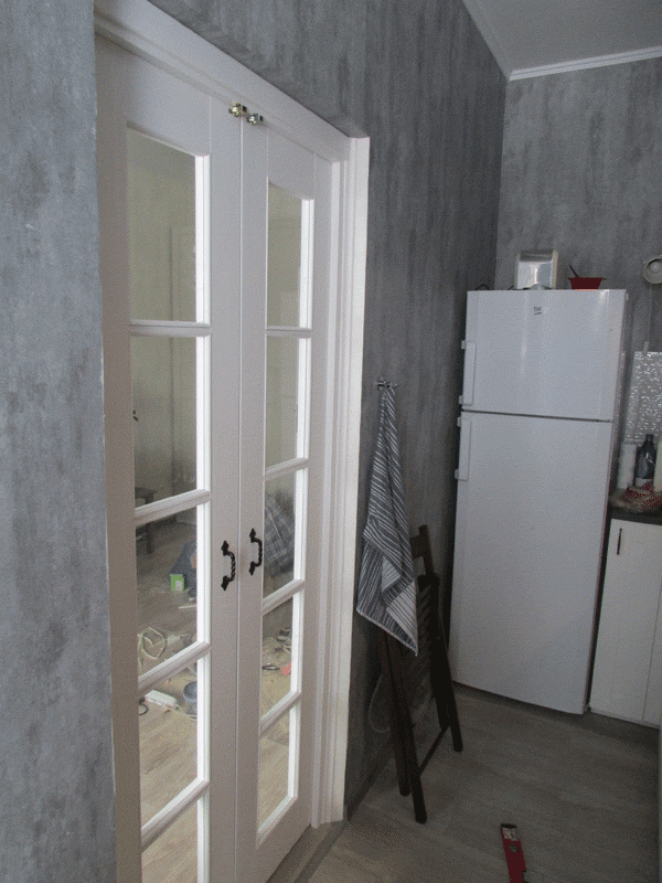Показана дверь со стороны кухни. Как то интересно видна комната, вроде отдельное помещение, а вроде и общее. Стеклянная дверь с расстекловкой создает красивый вид.