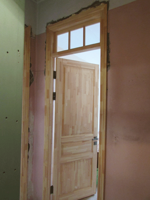 Фото установленной межкомнатной двери модели НЕВА сверху которой стоит фрамуга со стеклом. 