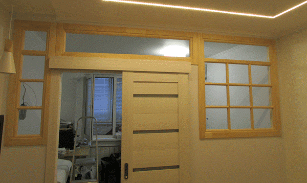 Фото перегородки с откатной дверью и установленными декоративными глухими окнами с верандной расстекловкой 