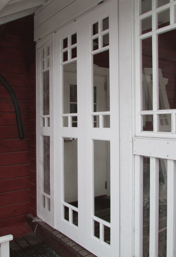 Деревянная перегородка белого цвета установлена на веранде в загородном доме.