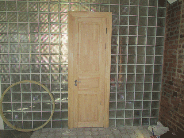 В перегородку из стеклянных блоков установлена дверь из массива сосны модели НЕВА