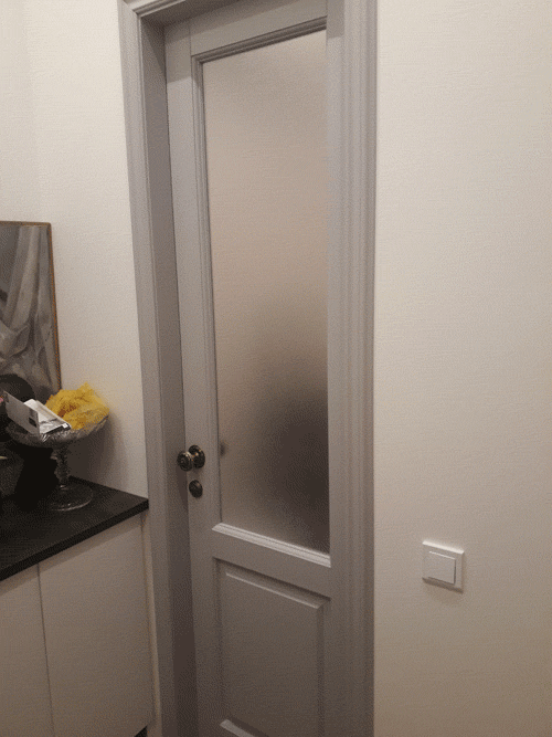 Фото дверного блока КЛАССИКА со стеклом, покрашеного в серый цвет. Установлена в комнате московской квартиры.