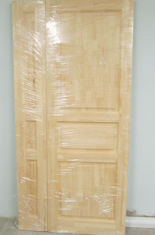 Фото двустворчатой полуторной деревянной двери из массива сосны. Одно полотно занимает 1/3 всей ширины, второе 2/3